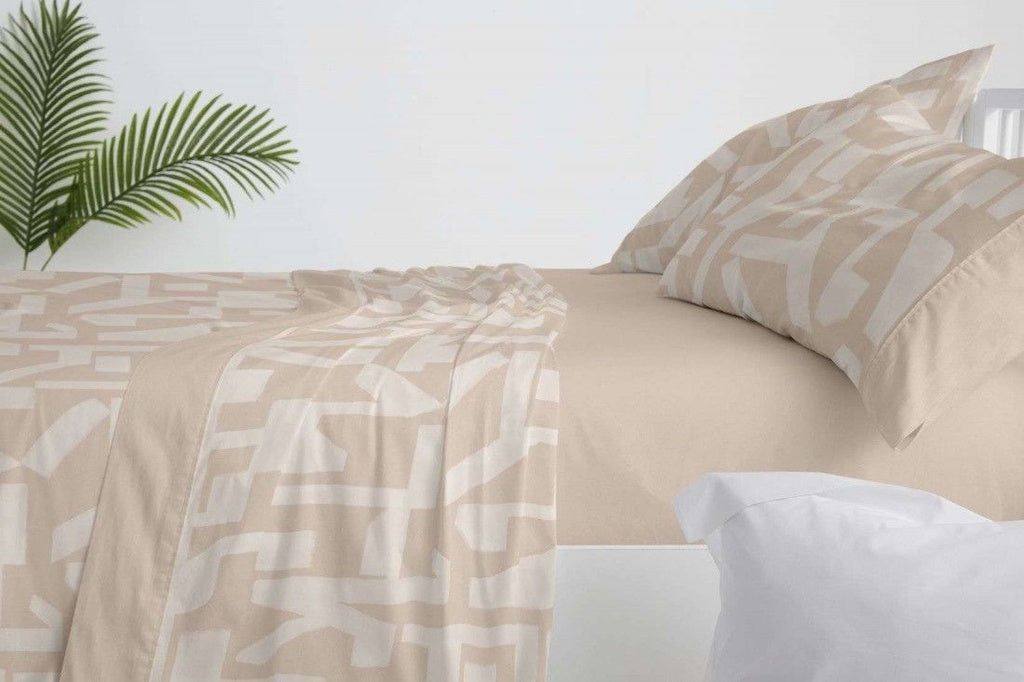 Primer plano de estampado geométrico abstracto en tonos beige sobre sábanas Burrito Blanco arcilla.